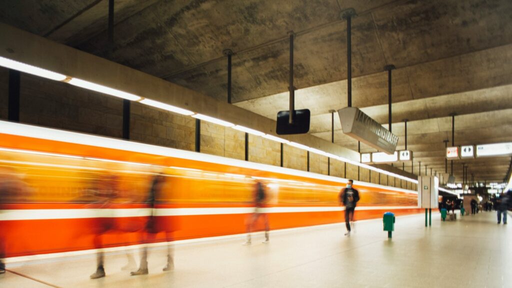 Einfahrende U-Bahn in einer unterirdischen Station, Fahrgäste auf dem Perron